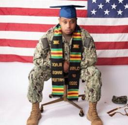 Student in military garb and graduation cap with a scarf that says 