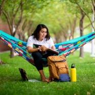 Woman in a hammock with a notebook and bag