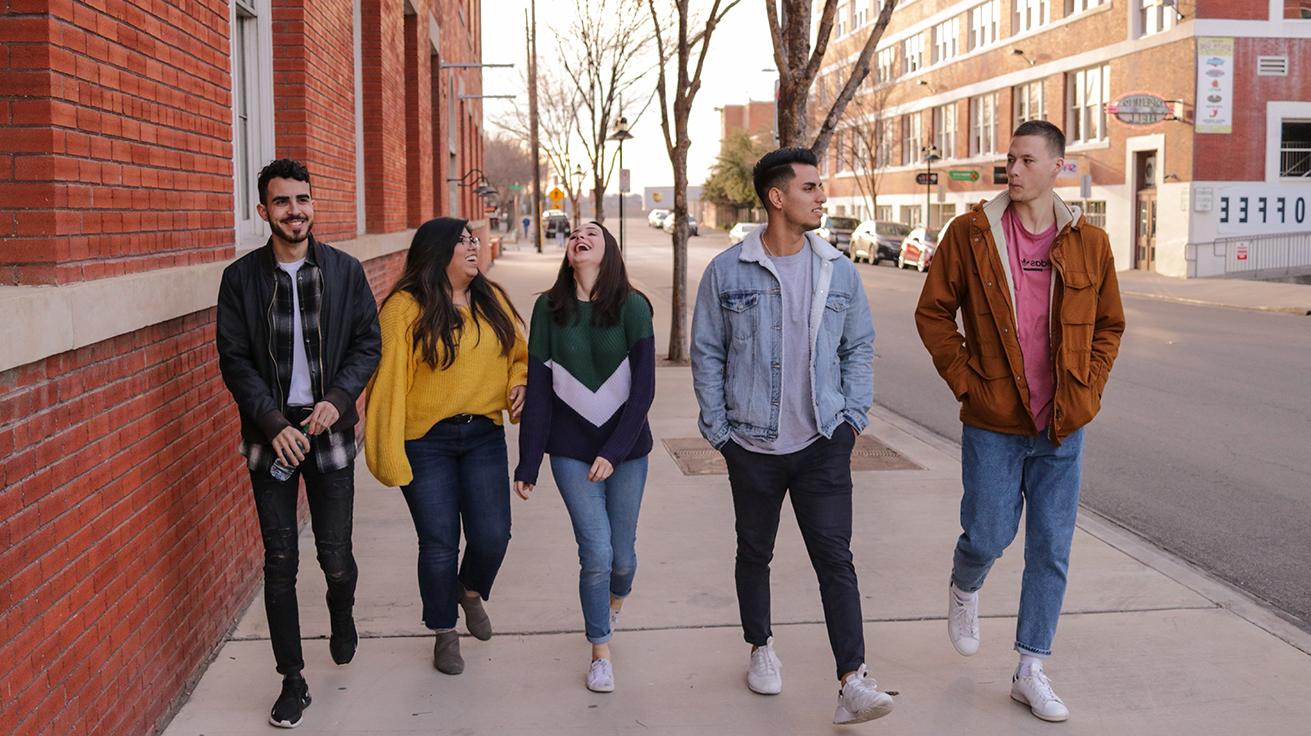 Group of students walking, smiling, and laughing