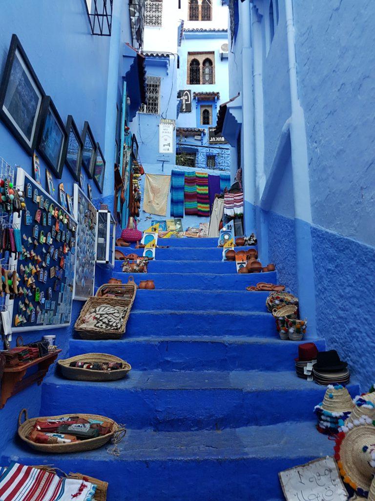 Blue stairs covered in straw baskets full of handmade items