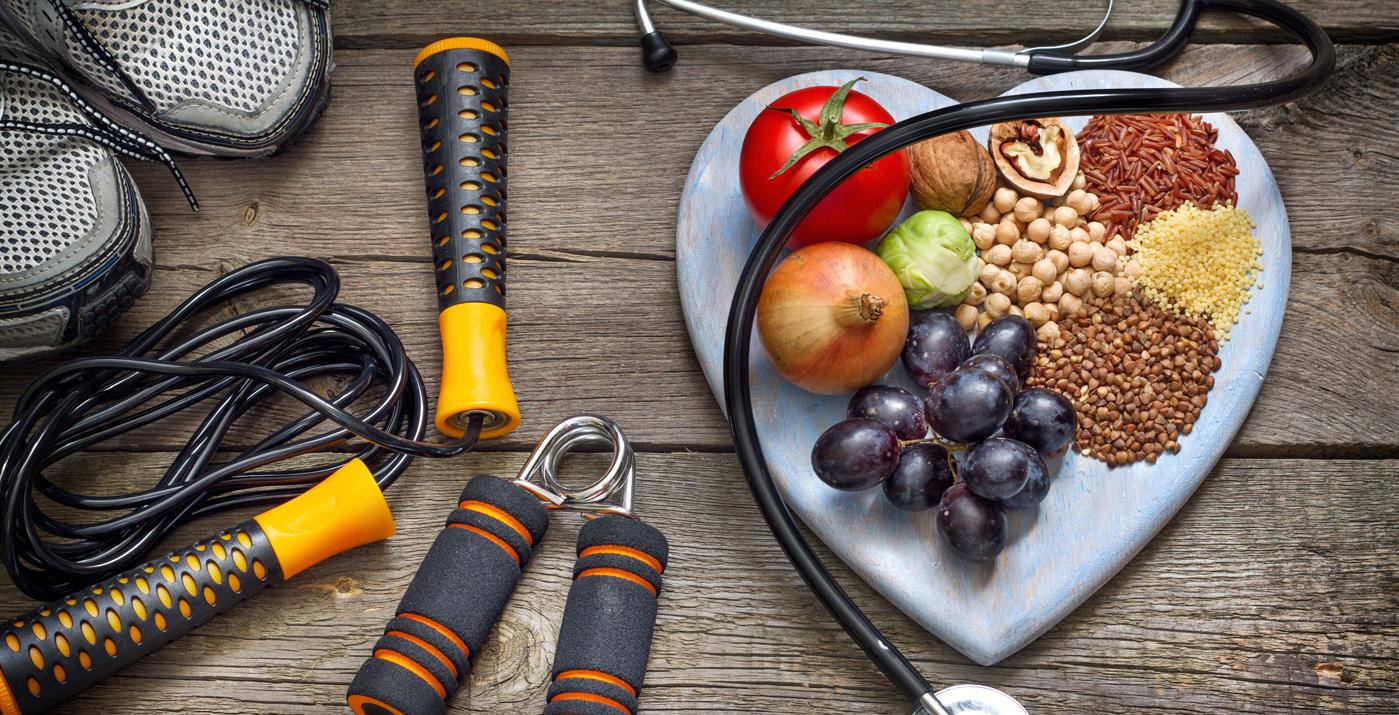 plate of vegetables, nuts, legumes, next to a stethescope, running shoes and jumping rope