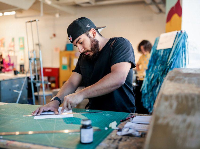 MSU Denver student Alexis Vasquez cuts paper in Painting and New Contexts class on May 3, 2023. Photo by Alyson McClaran